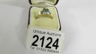 A blue topaz oval cut ring with 2 diamonds set in mount in 9ct gold, size P.