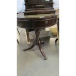 A dark wood stained drum table with 3 drawers and gilt decorated green leather top, height 60 cm,