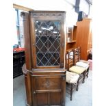 A dark oak lead glass glazed corner cabinet,