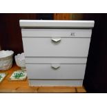 A white bedside chest of drawers with glass top, height 52cm, width 45cm approx.