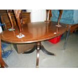 A darkwood stained oval dining table with brass string inlay on centre column, Height 74.