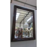 A dark wood framed mirror.