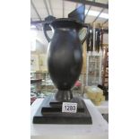 A cast iron urn with stepped base, 27.5 cm.