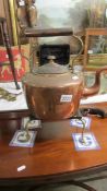 A large Victorian copper kettle and a brass trivet.