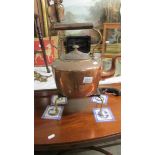 A large Victorian copper kettle and a brass trivet.