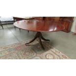 A large circular mahogany dining table, 520 cm (60" diameter).