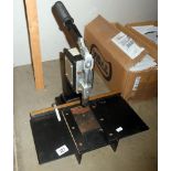 A manual framing press for attaching hangers and rings to picture frame backboards
