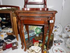 A darkwood nest of tables with green leather inset and glass tops, Height 53.