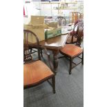 A mahogany extending wind out table with one leaf and a set of 6 chairs.