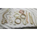 A quantity of 'pearl' necklaces and bracelets.