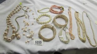 A quantity of 'pearl' necklaces and bracelets.