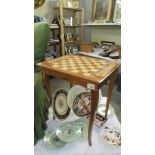 An Italian? inlaid musical games table with chess board top with contents including dominoes,