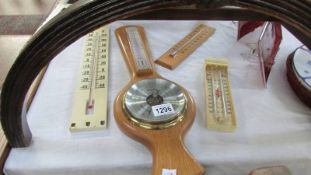 An oak Comitti of London barometer and three thermometers.