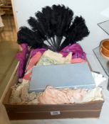 A box of assorted textiles including lace, dresses,