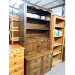 A dark oak drawer based dresser with carved drape panel doors, Height 194cm, width 94.5cm approx.