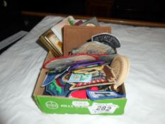 A box of sew on patches including girl guides, plus pin badges, small books (Scottish songs,