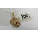 A stone set floral design pendant (tests as 18ct gold).