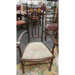An Art Nouveau inlaid elbow chair in good condition.