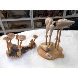 A carved wooden mushroom and bird family displays