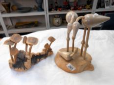 A carved wooden mushroom and bird family displays