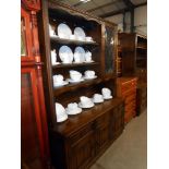 A dark oak cottage dresser with leaded glass doors and drape panels