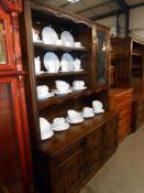 A dark oak cottage dresser with leaded glass doors and drape panels