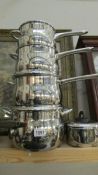 A set of four good quality stainless steel saucepans and four other stainless steel sauce pans.