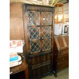 A dark oak cottage corner cupboard with leaded glass doors, height 169cm, width 66cm,