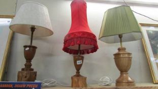 Three craftsman turned wooden table lamps with shades, approximate heights 57 - 65 cm.