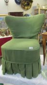 An Edwardian wing nursing chair with green cover.