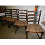 A set of 4 ladder back chairs with upholstered seats.
