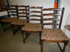 A set of 4 ladder back chairs with upholstered seats.