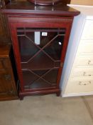 A darkwood stained display cabinet with decorative door, Height 99cm,