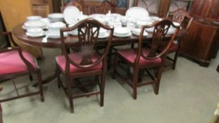 A mahogany extending dining table and a set of 6 shield back dining chairs.