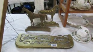 A Victorian brass 'Home Sweet Home' trivet top and left and right facing brass horse door stops.