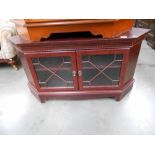 A dark stained tv cabinet with glazed doors, height 59.5cm, width 111cm, approx.