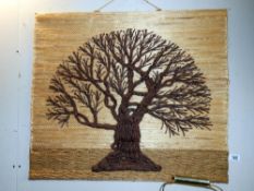 A decorative wall hanging of a tree (crafted from wool on hessian)