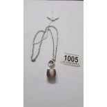 A Ti Sento Milano pendant with chain, stone set in pink, cats eye style, length approximately 40 cm.