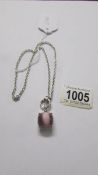 A Ti Sento Milano pendant with chain, stone set in pink, cats eye style, length approximately 40 cm.