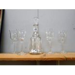A glass decanter and 4 long stemmed wine glasses