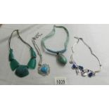 A white metal leaf necklace set blue stones and 3 turquoise coloured necklaces.