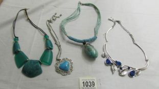 A white metal leaf necklace set blue stones and 3 turquoise coloured necklaces.