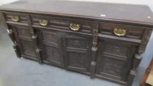 A carved dark wood stained sideboard.