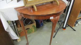 A dark wood stained D shaped hall table on Queen Ann legs.