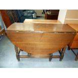 A 1930's oak gateleg table on turned legs, Height 75.