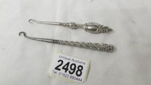 An antique hall marked silver handled button hook and another silver handled button hook.