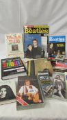 A mixed lot of Beatles related items including books, tapes, 45 rpm records etc.