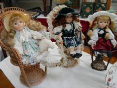 3 porcelain collector's dolls on cane chairs.