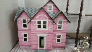 A pink dolls house with furniture. ****Condition report**** Width 76cm, height 73cm.