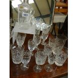 A cut glass decanter and a quantity of glasses.